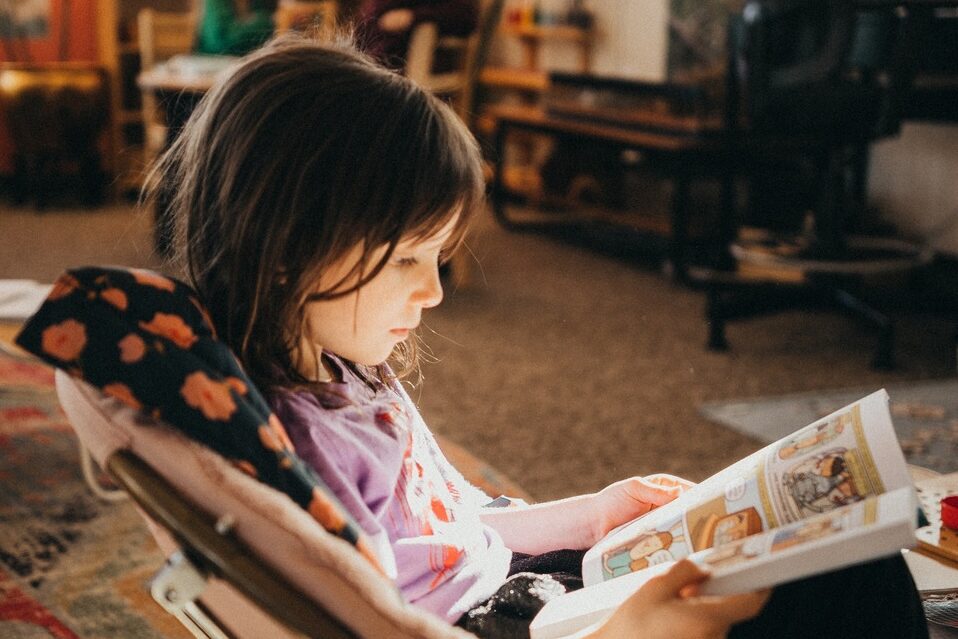 Lower elementary Montessori student reading independently at Soaring Wings