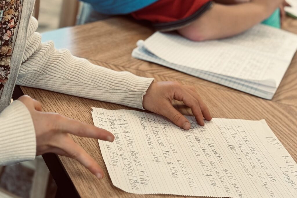 Upper elementary student writing a haiku during Montessori language work